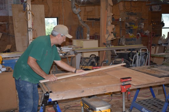 The author puts the solid end of the trammel beam at the pivot point and swings the arc with the pencil end to make sure it fits properly.