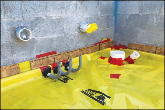 Figure 7. OSB strips fastened over the membrane to the CMU walls hold it in place until the slab is poured. Pipe openings in the membrane are sealed either with Stego tape or with black Stego Mastic, which is made for sealing around pipes.