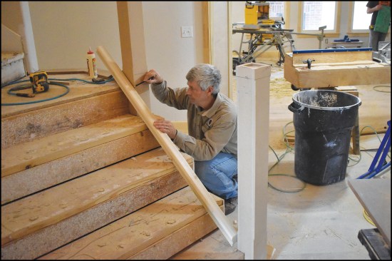 For a precise fit between the stair newels, the author laid the stair rails across the treads to mark their length.