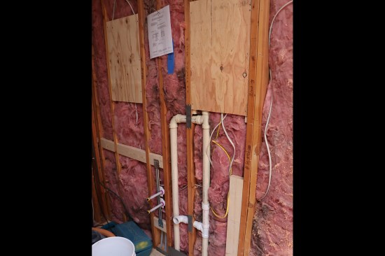 To help with jobsite communication, the design plans are posted on the walls, and the locations of critical items are marked on blocking and studs.