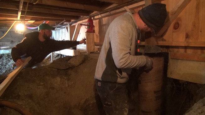 Chris positions the Sonotube in place over the precast pad and rebar and underneath the existing wood post.