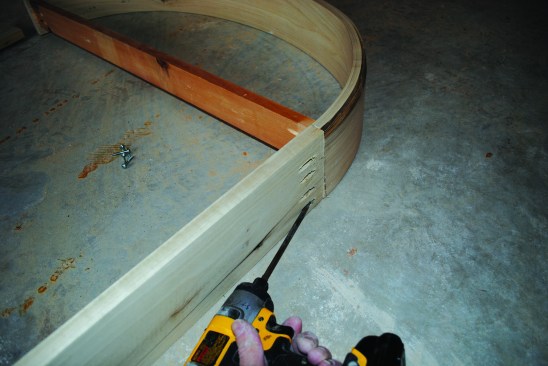 A temporary spreader holds an arch at the proper width while legs are screwed on. Note that this is one of the rare occasions that you need to screw into the end grain.
