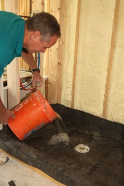 When the membrane is installed and all the joints are appropriately sealed, insert an expansion plug into the drain and dump about 10 gallons of water into the shower pan. Let the pan sit filled with water for three to four hours. Carefully inspect the drain and the floor below the shower for leaks before proceeding to the next step. 
