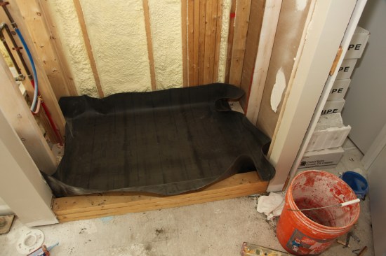 Always use a waterproofing membrane specifically meant for shower floors. When measuring the membrane, be sure there’s enough to go up the walls at least 2 inches above the threshold around the perimeter of the shower. There also needs to be enough material to wrap over the top and down the outside face of the threshold. Place the membrane in the shower with the same overlap on all sides. 