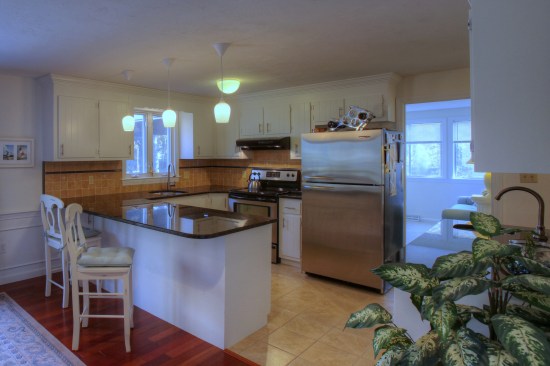 A flush-mount light in the center of the kitchen can work in concert withpendants over a peninsula.