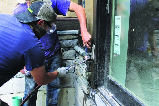 The mason applies heat with an acetylene torch. The heat turns the water to steam.