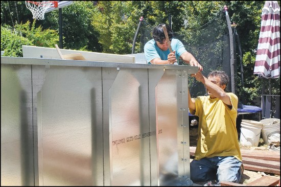 Figure 10. Workers assemble the modular kit’s galvanized steel panels. Polyiso rigid insulation was later installed in the panel bays, as shown in figure 1.