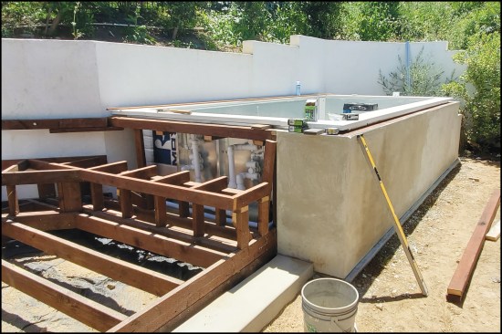 Figure 12. An abutting deck with bench seating was installed, with an access panel to the hydrotherapy jets built into the seating. The pool’s walls were clad with a smooth stucco finish.
