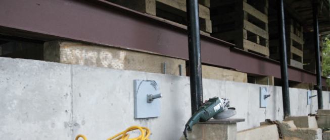 Three-quarter-inch–thick steel plates on the outside of the grade beam capture the ends. Note the two steel I-beams sitting on top of the grade beam, ready to be welded together to form one long support.