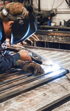 A hydraulic press punched holes into the rails for the baluster spindles, and the various pieces were then welded together.