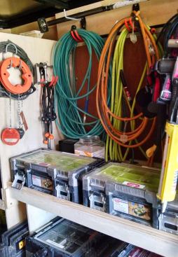 Hoses and cords store in a recessed area towards the front right side of the trailer. The storage boxes below carry the Keter label; the same boxes can be found with the Husky label at Home Depot. 
These boxes are subdivided inside and more reasonably priced than similar L-Boxxes and Systainers.