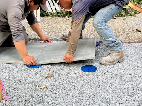 All four corners of each paver need to be set onto spacer plates.