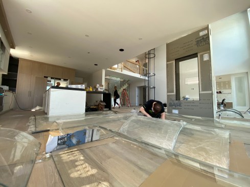 The installation was managed by Savaria, the manufacturer, freeing the author from the delivery and long-term service of the unit. On this install, it helped that the jobsite had ample room to lay out the curved glass panels for the walls of the shaftway.