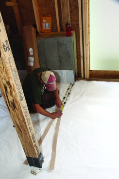 The crew laid out the poly sheets so the seams broke near the lines of columns wherever possible; as they taped the seams, the crew carefullyunrolled the tape with the backing split to keep the roll centered on the seam.