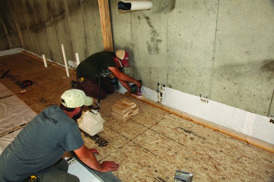 Because the subsequent courses had to be driven together to engage the tongue-and-groove edges, solid backing was created by putting a2x4 against the back of the first course and then screwing down scrap blocks that rested against the foundation.