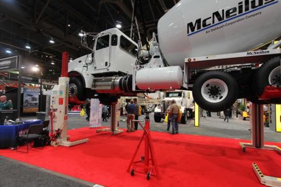 Stertil Koni's heavy 
duty lift system can lift and amazing amount of weight. The units under this truck are battery powered and each can lift 22,000 pounds. I watched the thing go up and down a couple of times and lifting a concrete truck was no strain at all. Jay Leno has something like this in his garage (or maybe it should be "in one of his garages"). 
Click here to see it in action.
