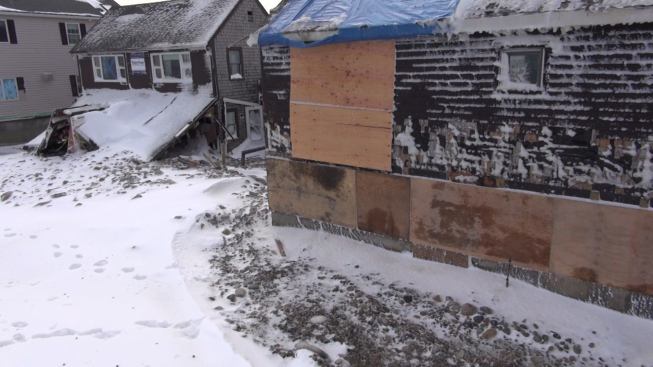 The oceanfront faces of two Marshfield houses bear the marks of battering waves and wind-driven flood waters after the January 2015 storm. Both of these houses were totaled by the nor’easter.