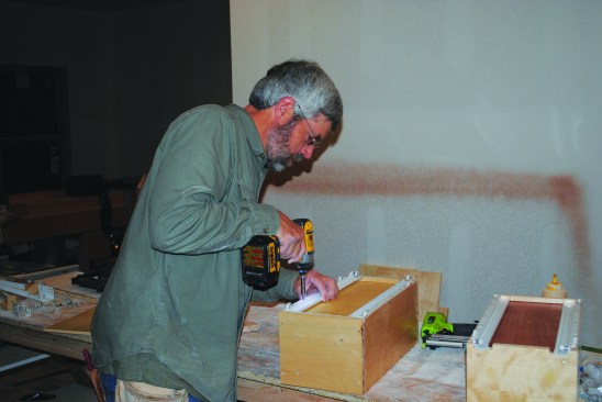 The drawer slides attach to the bottom via predrilled holes.