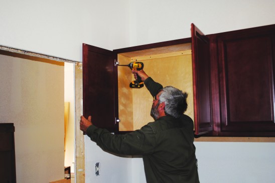 Then he aligns the face frames and screws them together, and permanently screws the cabinets to the wall. Cabinet doors are attached last.
