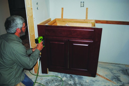 To fill in a space at the end of a cabinet run, a 1-by backer holds a ripping of finished plywood.