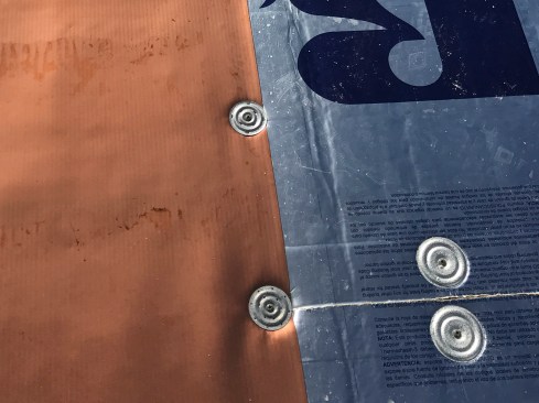 The author prefers to mechanically fasten the membrane to the deck. Here, proprietary, 2.4-inch “membrane stress plates” (or “seam plates”) were installed along the up-slope edge of each 6-foot-wide course, on 12-inch centers. Note, these membrane stress plates are different from the ones used to fasten down the insulation.