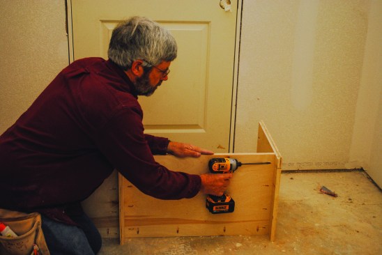 The base section assembles  much like the upper section  except that it is shorter and  deeper. The author attaches  the bottom shelf 4 inches  from the bottom of the box  to create a kick space.