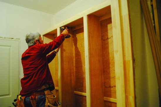 Combined unit. The base section is set in place first, then the upper section sits on top. Screws driven through the upper cleat  and into the wall framing secure the upper cabinet in place.