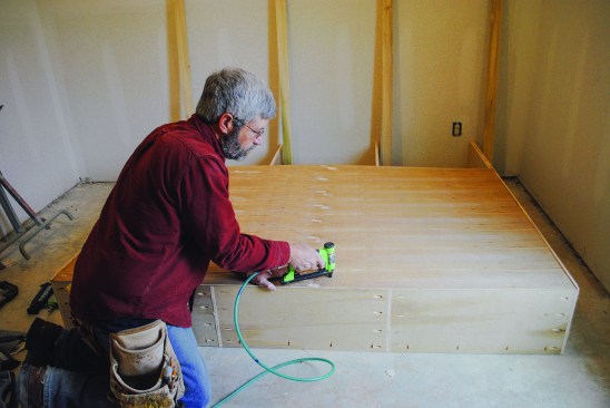The back. Because the  upper cabinet is more than  4 feet tall, the back consists  of two pieces. The author  glues and nails the 1/4-inch  plywood back to the cleats  and to the verticals.