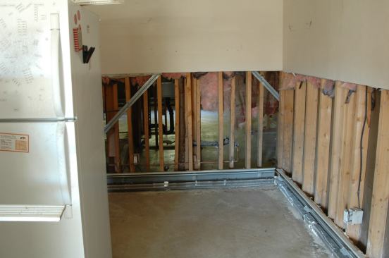 The flooring, drywall, insulation, and kitchen and bathroom base cabinets have all been thrown out and the ruined appliances are awaiting pickup.