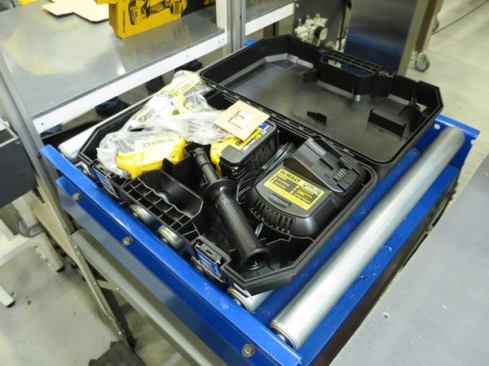 This tool kit is resting on an electronic scale. Why do they weight it? The weight will be off if something is missing—like the belt clip or manual. If the weight checks out they shut the case and enclose it in one of those cardboard wrappers that cover the center of the case but not the ends.