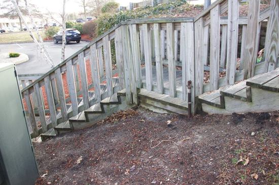 This treated wood staircase near a motel in North Dartmouth, Mass., dates back to the 1990s, and was constructed with CCA lumber before the arsenic and chromium formula was phased out. The 2x10 stair stringers are partially buried in the earth. Today, 2x10 lumber treated with MCQ, MCA, or CA preservative formulas would not be approved for this use because the wood contains a lower concentration of the treating formula in order to reduce the treatment cost.