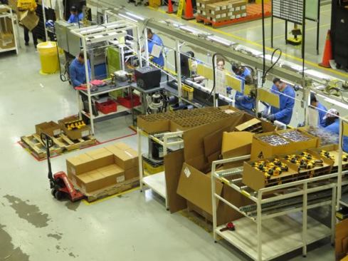 Components are staged along the back side of the cell on sloped rollers so as one box of parts is depleted another rolls forward to take its place.