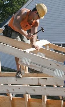 Precut 1x2 spacers 24 inches long are nailed between trusses as each truss is set.