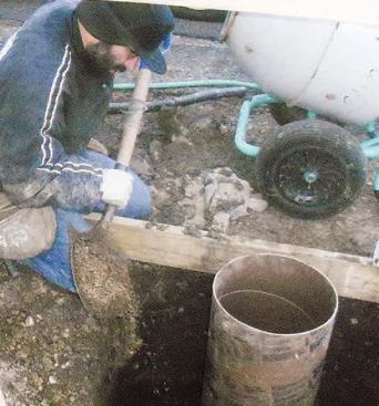 I add dirt and rocks around the tube, tamping as I fill to prevent voids, until I'm about halfway up.