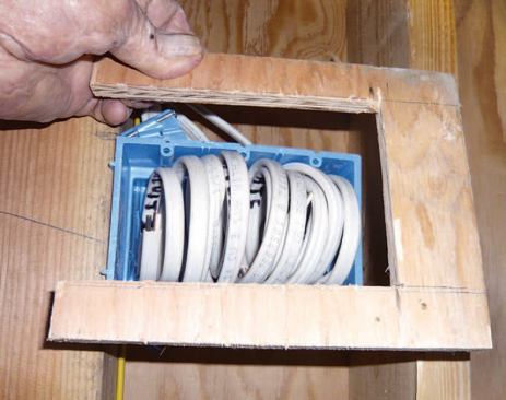 Although three-gang airtight electrical boxes were not available commercially, the crew made their own by cutting pieces of U-shaped plywood (C), caulking them to the box, and fastening the corners to the framing with finishing nails.