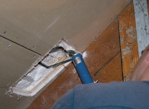 Inside, a worker makes a hole in the ceiling several feet away, then scoops out a recess with a hot knife.