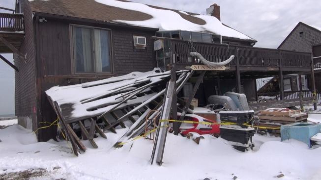 After the failure of a nearby stretch of concrete seawall, swirling ocean water crashed through the lower story of this house and undermined this deck on the landward side.