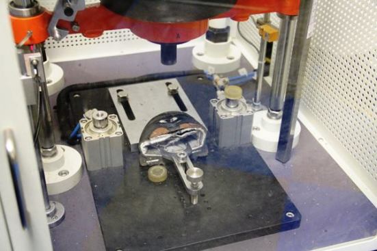 Keen tests the toes (steel, composition, or aluminum) by dropping specified weight onto a small area of the toe cap and then measuring the deformation. The goal is for the cap not to break or bend so far as to injure the wearer. Not shown are the machines use to advance age boot materials (looks like a microwave) or test the bond between the rubber outsole and the polyurethane midsole (a computer controlled gizmo that pulls the pieces apart). 
Click here for video.