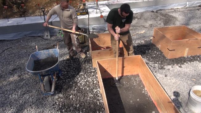 Compacting the crusher run on top of the trap rock inside the plywood form.