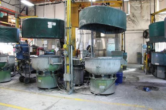 When a die punches a piece from a strip of steel it leaves a sharp burr on the edge. Burrs are removed by putting the pieces into a tumbler filled with ceramic pellets and a slurry of grit and water. The tumbler vibrates violently, churning the contents together and wearing the burrs off and putting a polish onto the pieces (
click here for video).