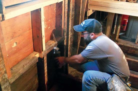 With the joists cut to fit just inside the exterior sheathing, it would be tough to slide them by the stools on the two windows, which faced each other from the center of opposing walls. My solution was to cut notches in the framing for the joists to slip through.