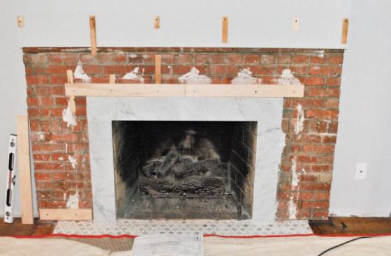 I started installation by attaching plywood backing to the brick with masonry screws, using a plumb laser and shims to get everything in the same plane