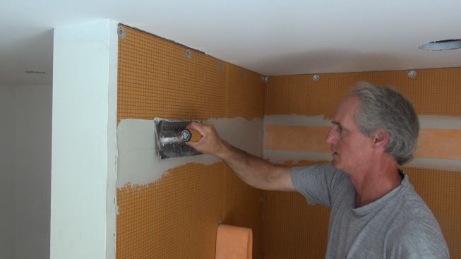 Boucher applies mortar to the surface of the Kerdi-Board, working the mortar thoroughly into the substrate with the flat edge of the trowel in order to ensure a good bond.