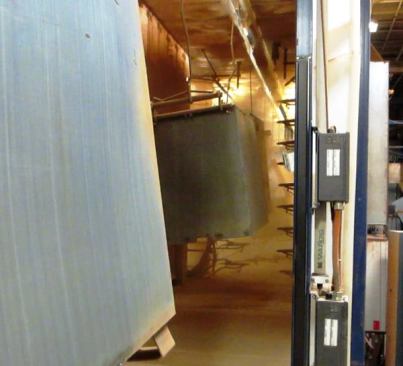 After the washed box or piece is dried and allowed to cool, it passes through an automatic powder coating unit (
click here for video). I saw several such units at the plant, each approximately the size of a semi-trailer. Sensors tell the heads when to spray; they only come on when there is something in front of them to be powder coated.
