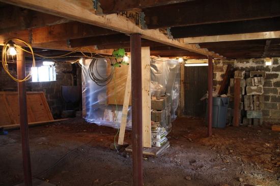 When jacking up the home’s roof and straightening its walls proved difficult, says Pollard, “we realized we had to start at the bottom.” Step one was to install new beams in the basement under the first floor frame and level the floor system.