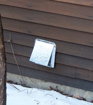 The screened air-inlet fitting on the outside wall is protected by a metal cap.