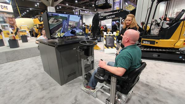 My friend Scott tries his hand at the excavator simulator at the John Deere booth. The company makes these for several machines because it's cheaper and easier to train on simulators than on the real thing. 
Click here for video.