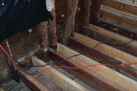 The exterior wall was framed at 16 inches on-center except under the windows, so I was able to use the studs to set the rough layout for most of the joists. The studs also gave me a place to attach the joist ends. For each joist, I checked the layout at both ends, and if they didn't land next to a stud, I added shims or blocking to the nearest one.