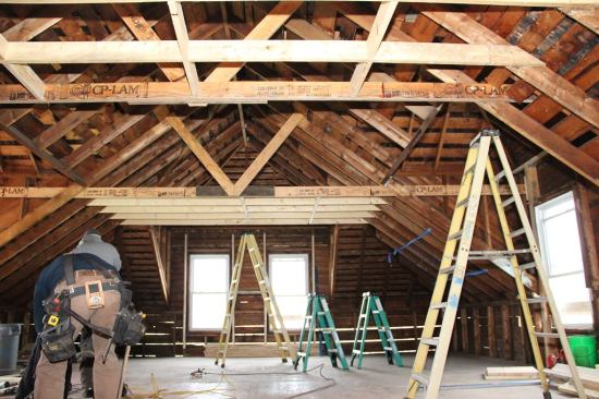 A view of the reframed and reinforced roof system after comealongs and jacks have been removed. Visible here is the pair of site-built structural trusses that now support the roof’s ridge beam and hips, as well as the new ceiling collar ties.
