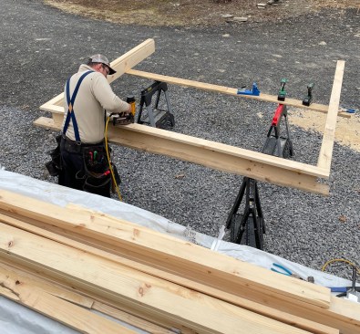 The crew prebuilds the jambs and casing for the garage doors using 5/4 #2 pine, easing the edges of the trim using a round-over bit.